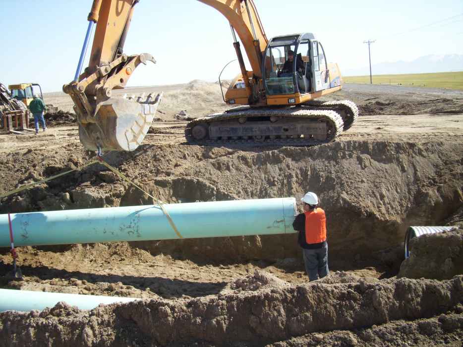 Excavator Laying Pipeline