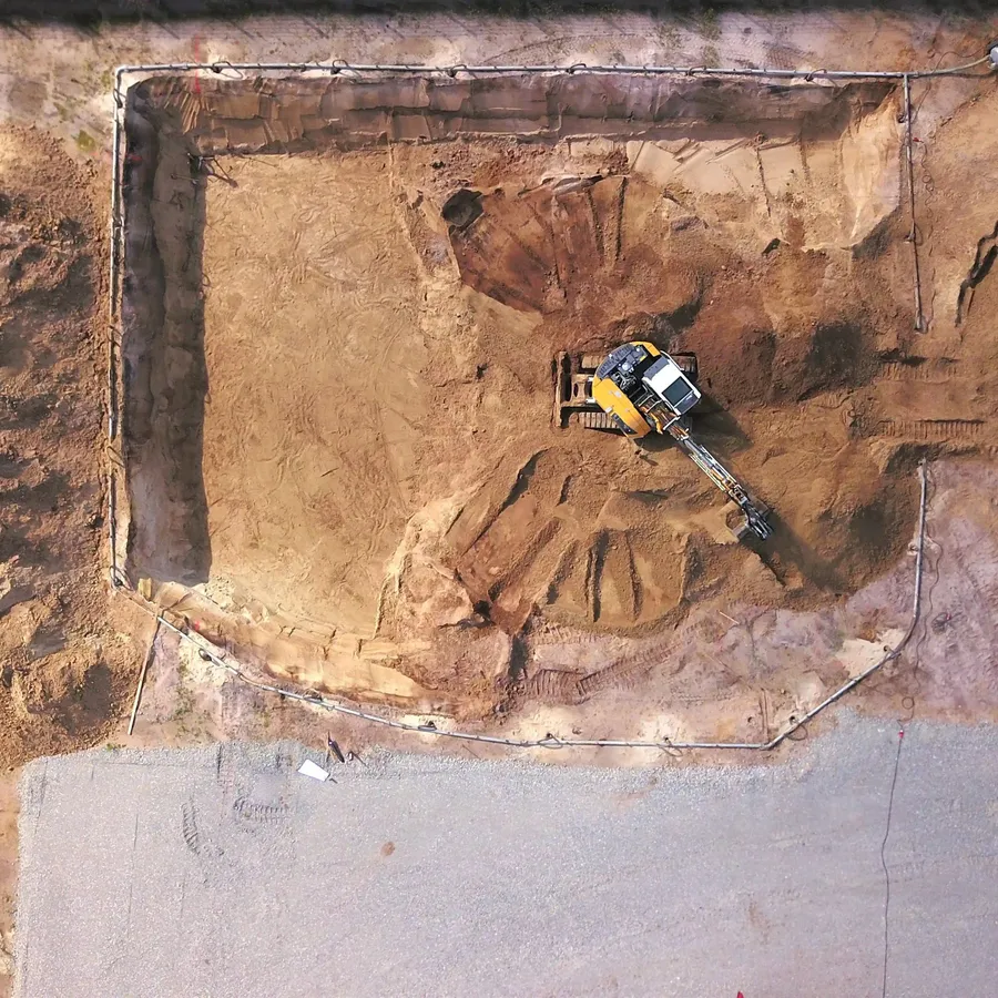 Excavator working a dirt and rock site for Streamline Precision